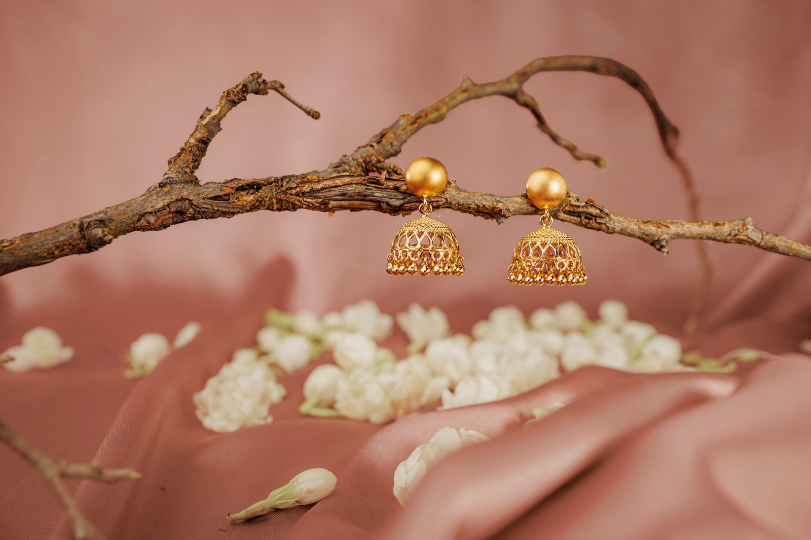 Sunar Collection gold earrings with white flowers on pink fabric